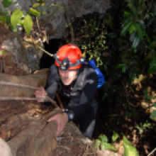 Domnique Rissolo roping up a cliff.